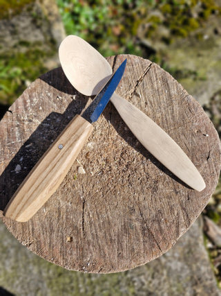 A Handmade Sloyd knife, with an Ash handle, resting on a hand carved Hazel spoon.