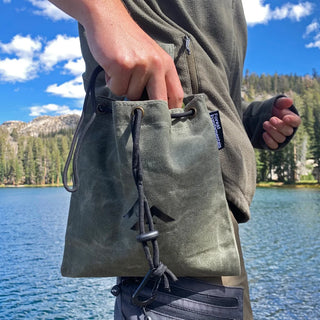 Forest Fundamentals Foraging Pouch - handmade waxed canvas pouch which folds up when not in use. Shown here on a model's belt.
