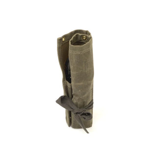 Frost River waxed canvas and leather tool roll with brass fittings and a cotton strap, shown here rolled ready for storage. 