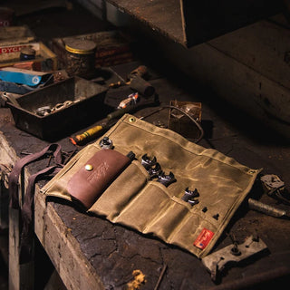 Frost River waxed canvas and leather tool roll with brass fittings and a cotton strap, shown here loaded with some of the tools you might want to use it for!
