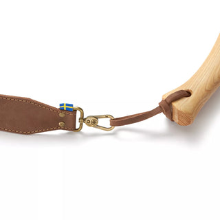 Hults Bruk Leather Axe Sling - a brown leather sling with brass fittings and a Sedish Flag logo, shown here attached to an axe handle
