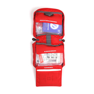 LifeSystems Adventurer first aid kit, a red pouch containing first aid supplies. Opened to view the quickfind system.
