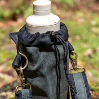 A green waxed canvas water bottle pouch, with extra pockets for other items, featuring a shoulder strap. The image shows the secure drawstring closure of the bottle section.