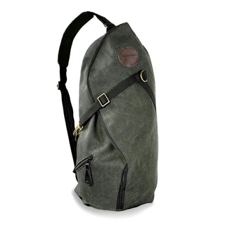 Green Waxed canvas sling bag, large enough to carry day to day esentials, featuring a leather logo patch, and brass fittings.
