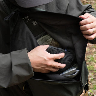 The DD Crosswind Sling bag, shown here diagonally across the front of a person's body, while they retrieve something. 