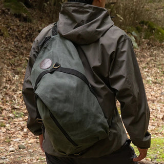 QQ Crosswind Sling bag, seen on the back of a model in a woodland setting