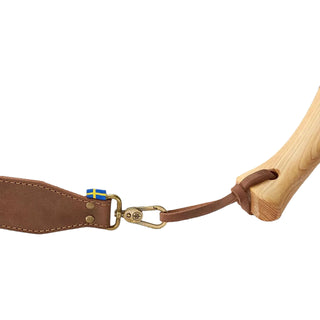 Brown leather axe sling with brass clasps and a Swedish flag label, connected to a wooden Axe handle