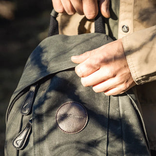 The green waxed canvas DD quest rucksack with zipped pockets and a top grab handle