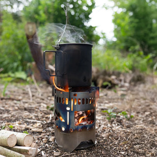 The Titanium camping cup sat on a folding stove with a lit fire.