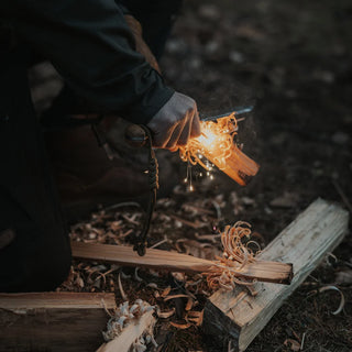 A shower of sparks from the Artisan Fire lighter, into a prepared feather stick to get a fire lit.