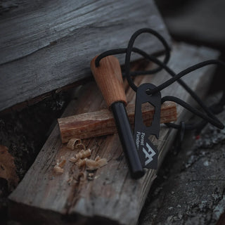 Forest Fundamentals Artisan fire lighter ferrocerium rod. Featuring a piece of Fatwood, a ferro rod, and a striker, tied together with paracord. This picture also shows shaving of fatwood. 